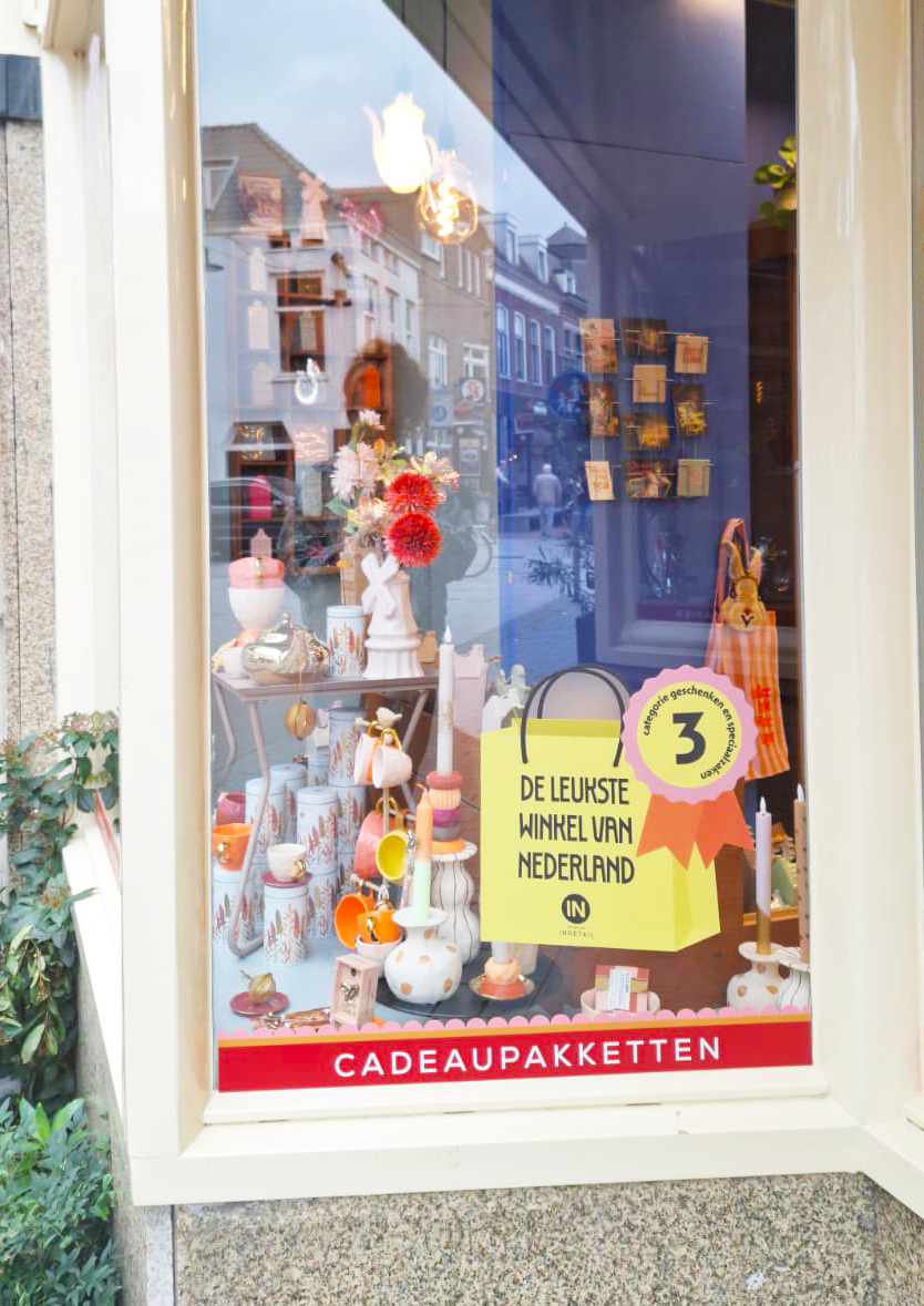 Op het raam van Buro Fudge is een sticker geplakt met derde plaats van Leukste Winkel van Nederland.